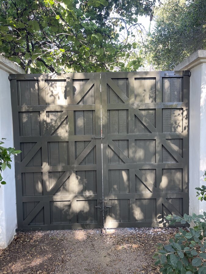 Arched gate with a rounded post cap detail in Montecito