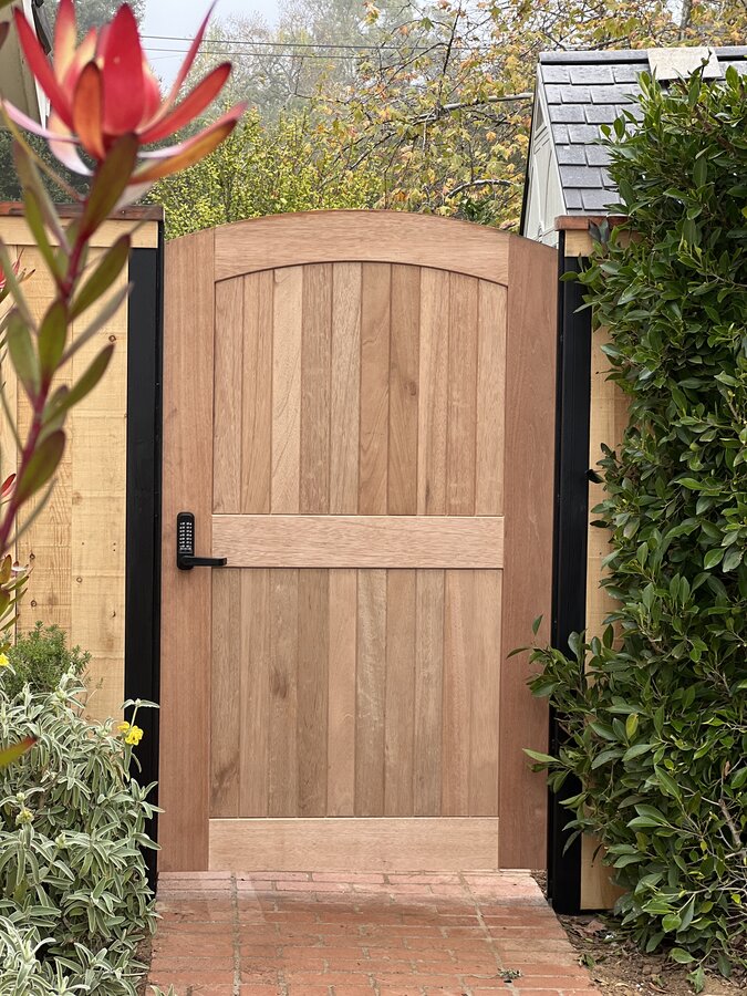 Arched hardwood pedestrian gate with black strap hinge in Santa Barbara