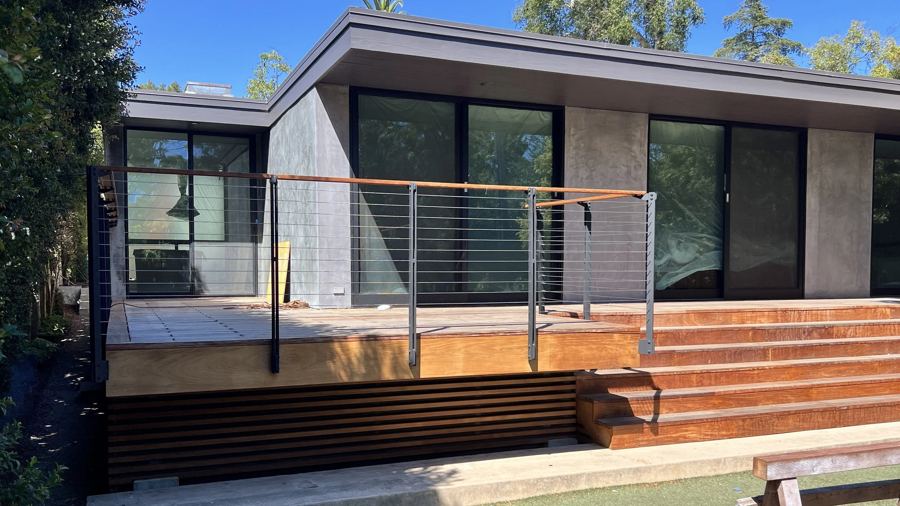 Cable railing with warm wood cap on a modern deck