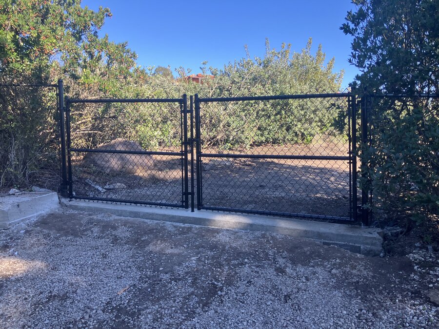 Chain-link double swing gate over a gravel drive in Santa Barbara