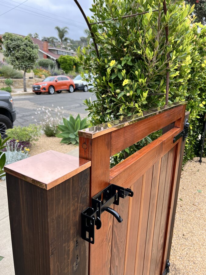 Copper-capped gate post with black hardware latch detail in Santa Barbara