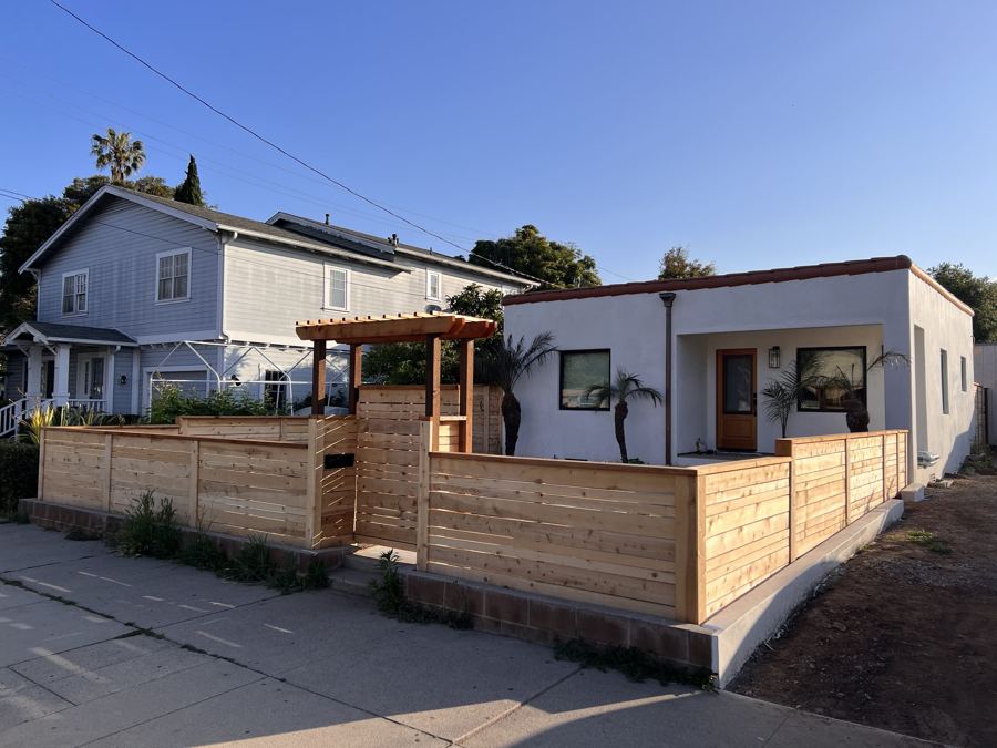 Corner pergola over a horizontal wood fence