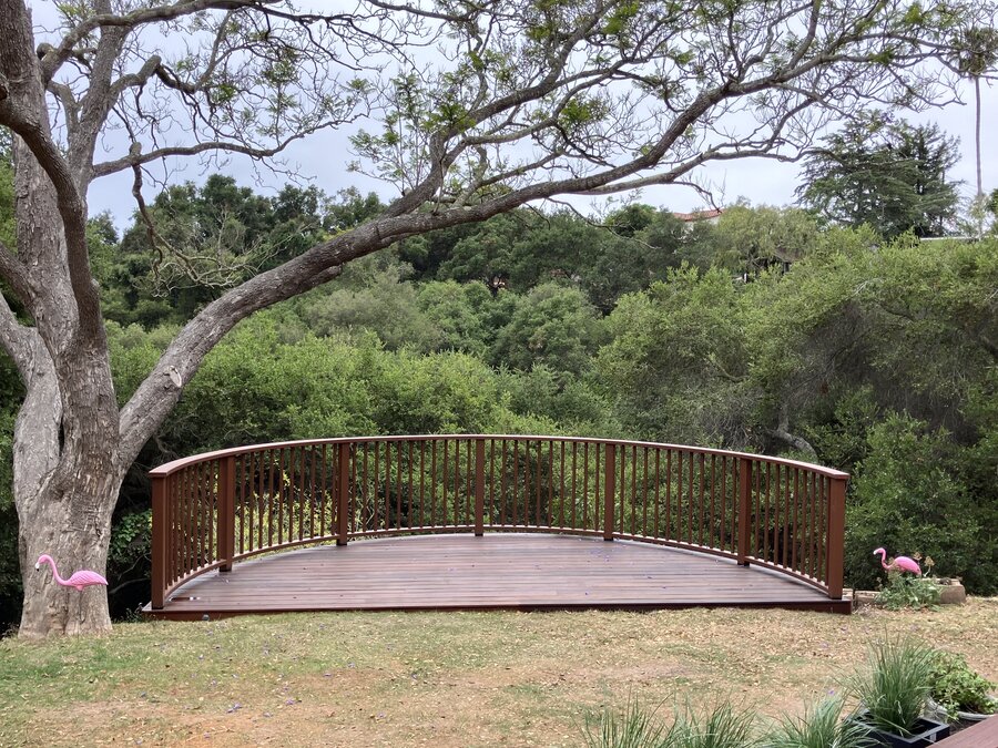 Curved wood garden bridge deck in a Santa Barbara backyard