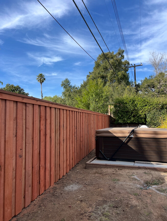 Cedar fence with decorative black laser-cut metal panel inserts in Goleta