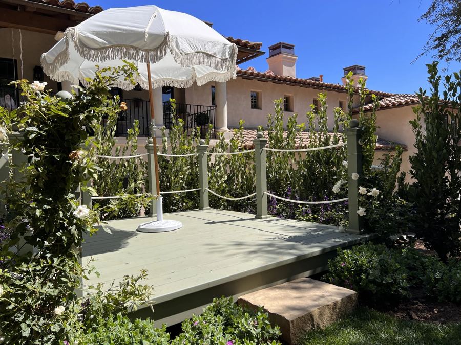 Garden deck with rope railing and fringe umbrella