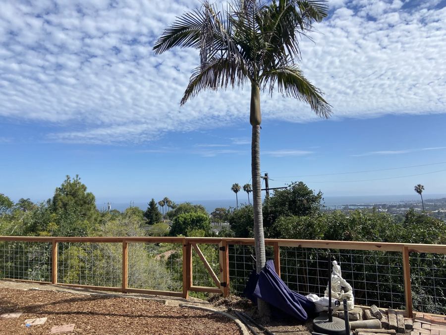 Wire and redwood fence with a coastal view