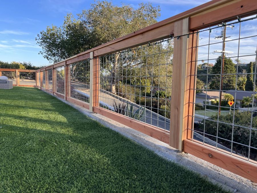 Hog wire and redwood fence along a hilltop lawn