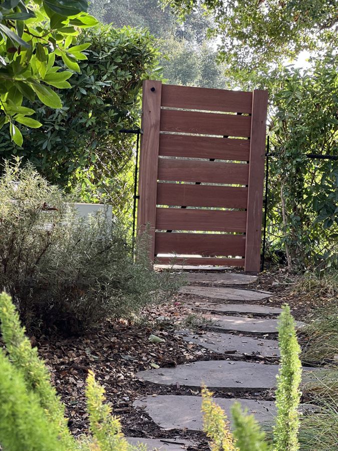 Horizontal slat hardwood pedestrian gate on a garden path