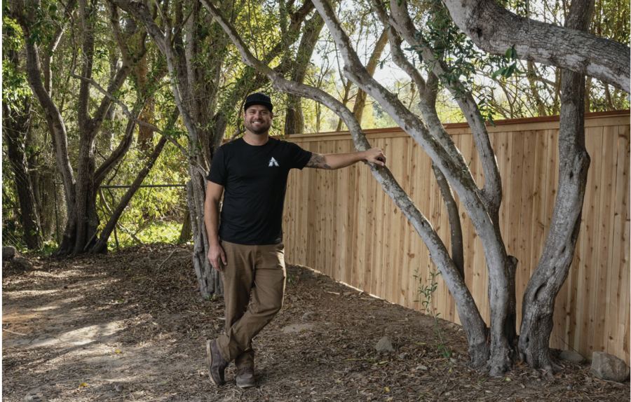 Kevin Herlihy, founder of Lighthouse Fence Co., beside a new cedar fence