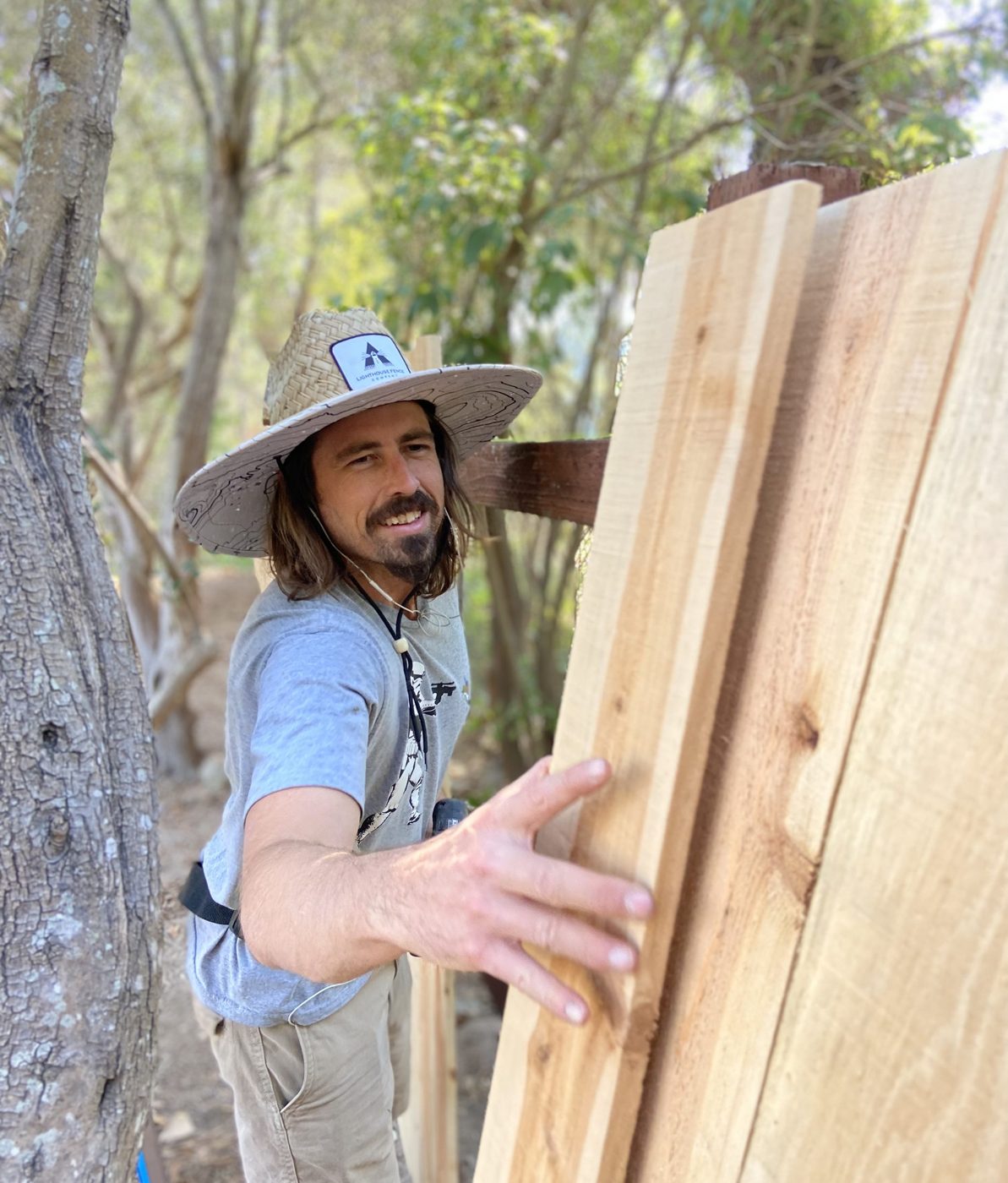 A Lighthouse Fence craftsman setting cedar fence boards on a Santa Barbara jobsite