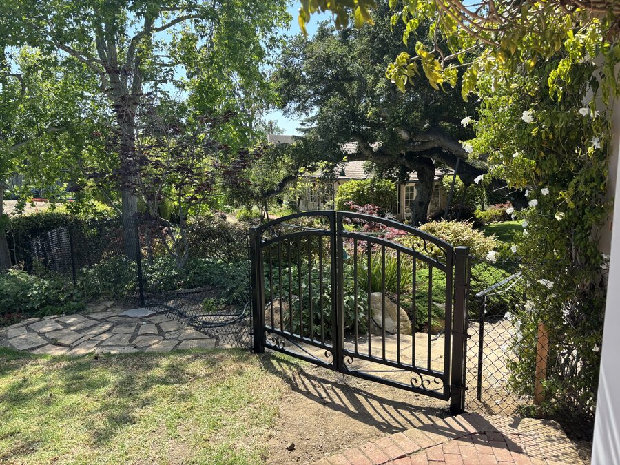 Ornamental iron scroll gate in a garden setting in Montecito