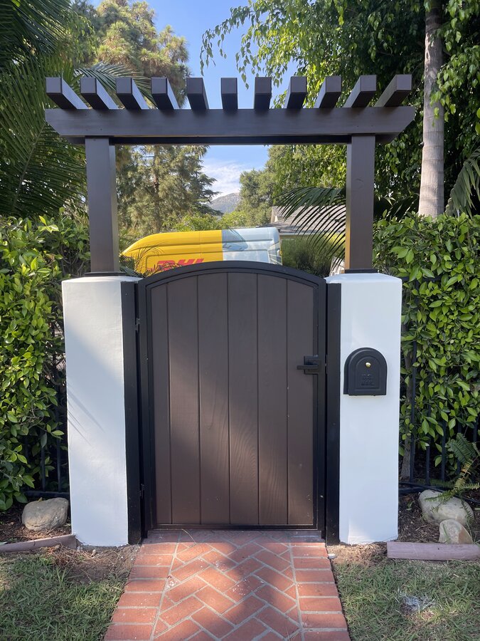 Pergola-topped arched gate with mailbox slot in Santa Barbara