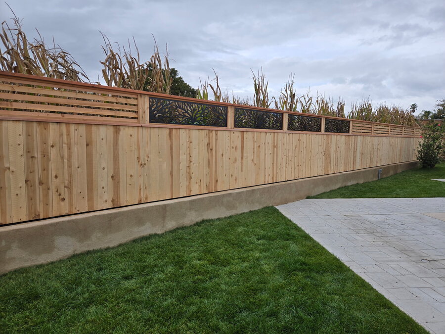 Redwood board fence beside a backyard hot tub