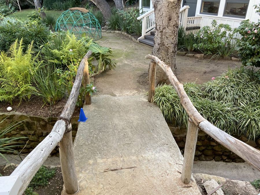 Rustic branch handrails on a garden footbridge