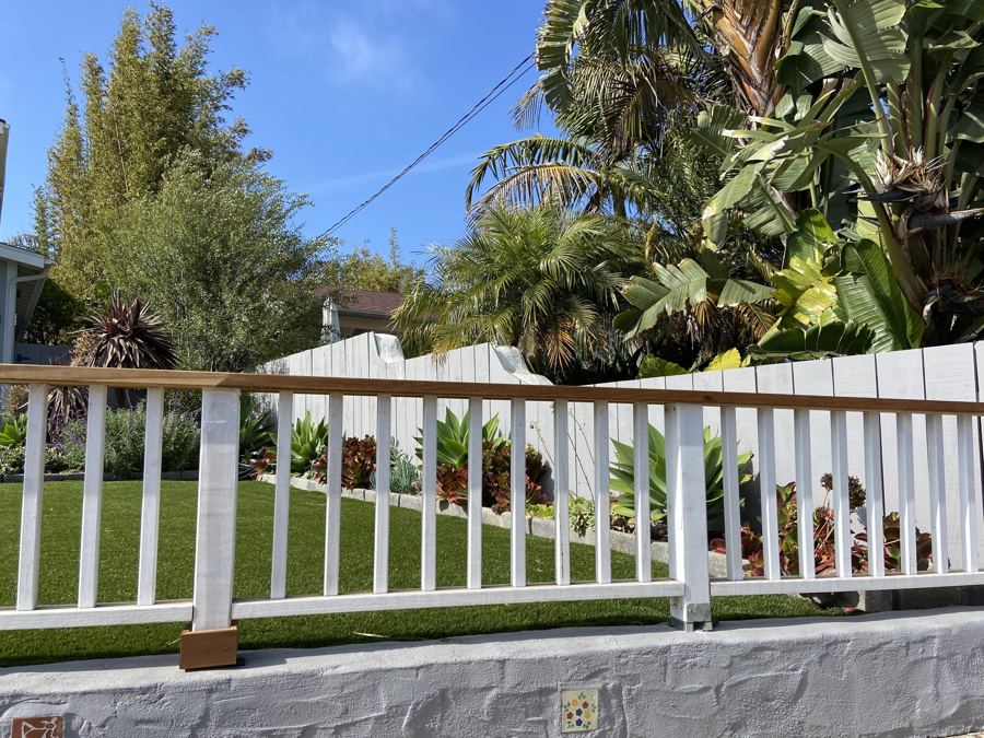 White picket railing with wood cap on a front yard wall